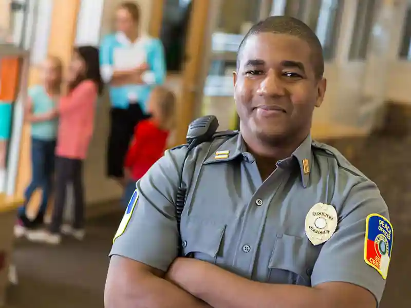 Police officer posing with his arms crossed.