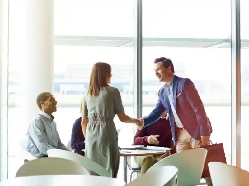 Professionals shaking hands after closing a deal.